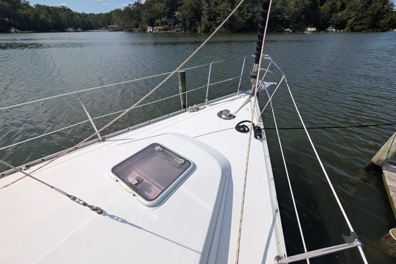 Slide: The Image of 2006 Beneteau Oceanis Clipper 373 sailboat on calm water, forested shoreline in background. - 4