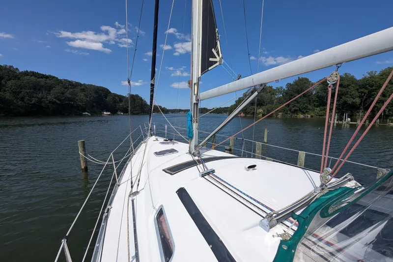 Slide: The Image of 2006 Beneteau Oceanis Clipper 373 sailboat on a serene river with lush green trees. - 8