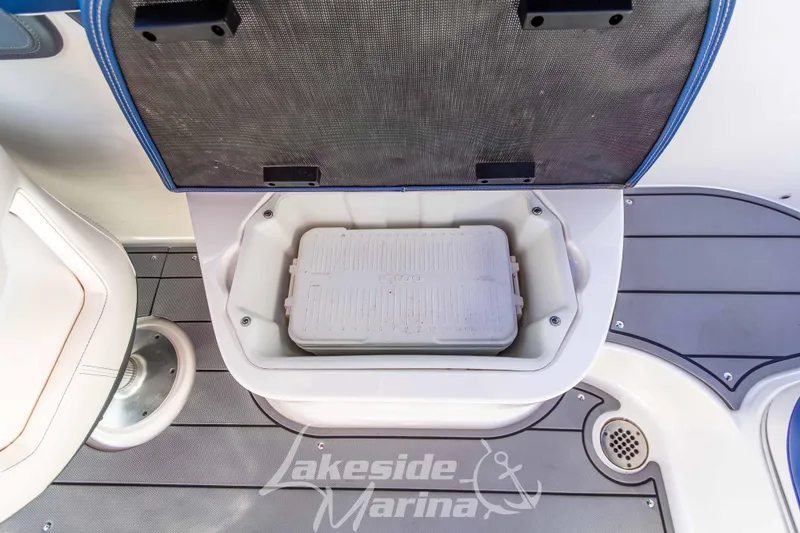 Slide: The Image of 2021 Chaparral 267 SSX boat cooler storage compartment with open lid. - 19