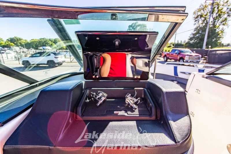 Slide: The Image of 2021 Chaparral 267 SSX boat interior with open storage compartment and windshield view. - 28