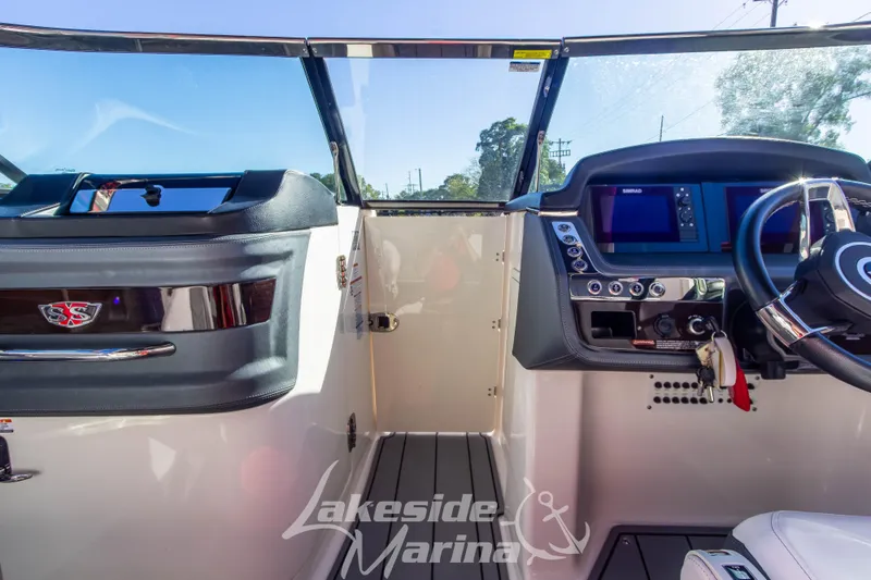 Slide: The Image of 2021 Chaparral 267 SSX boat dashboard with steering wheel and control panel. - 31