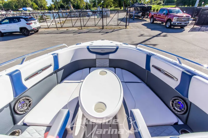 Slide: The Image of 2021 Chaparral 267 SSX boat interior with white and blue seating, outdoor setting. - 35