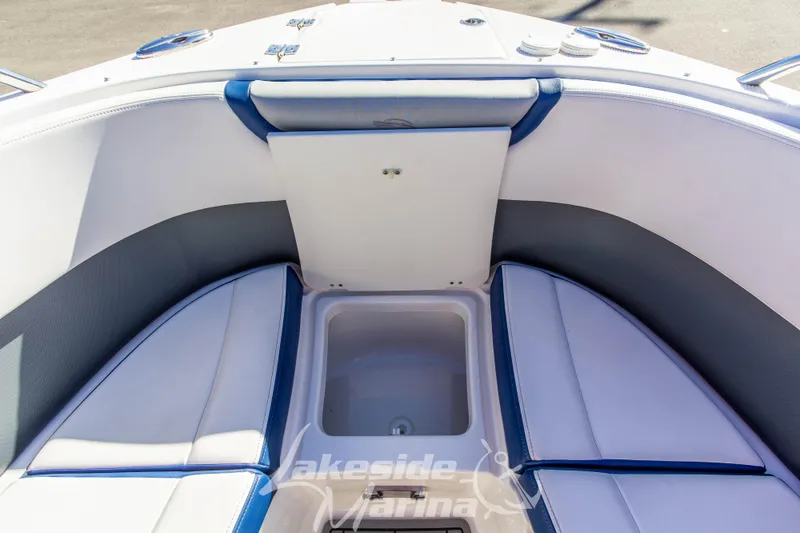 Slide: The Image of 2021 Chaparral 267 SSX boat interior with white and blue seating and storage compartment. - 39