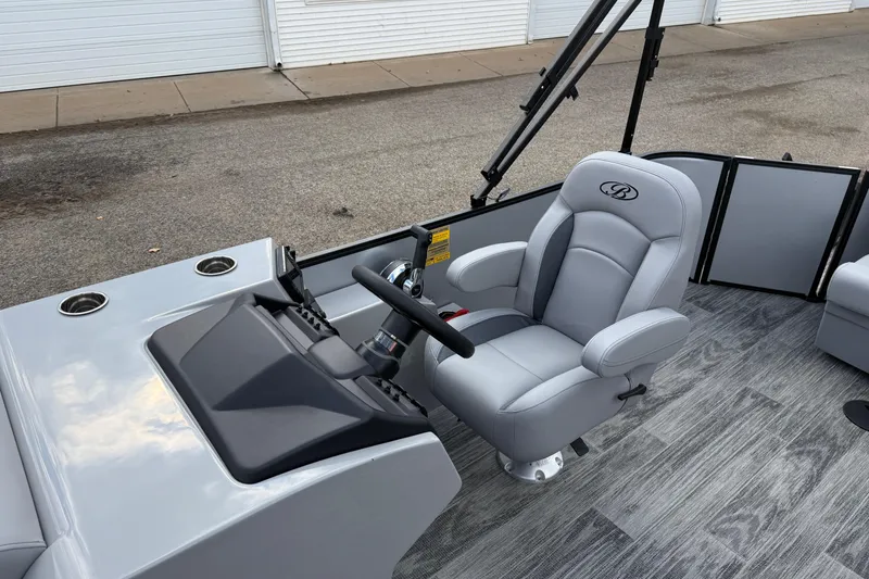 Slide: The Image of 2026 Bentley Pontoons Legacy 220 Cruise XL interior with captain's chair and steering console. - 16