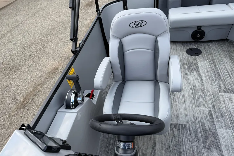 Slide: The Image of 2026 Bentley Pontoons Legacy 220 Cruise XL captain's chair and helm, featuring sleek design and controls. - 18