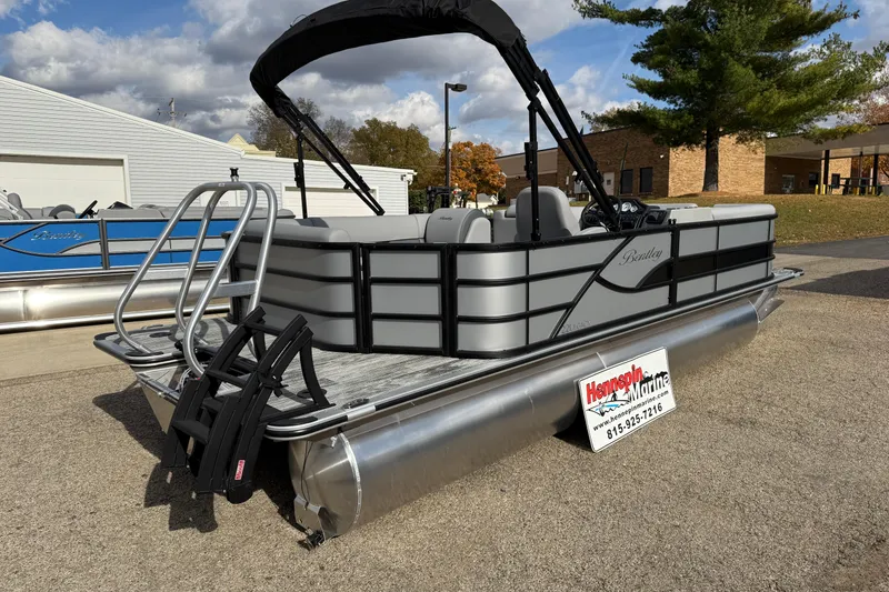 Slide: The Image of 2026 Bentley Pontoons Legacy 220 Cruise XL, gray pontoon boat with canopy, parked outdoors. - 4