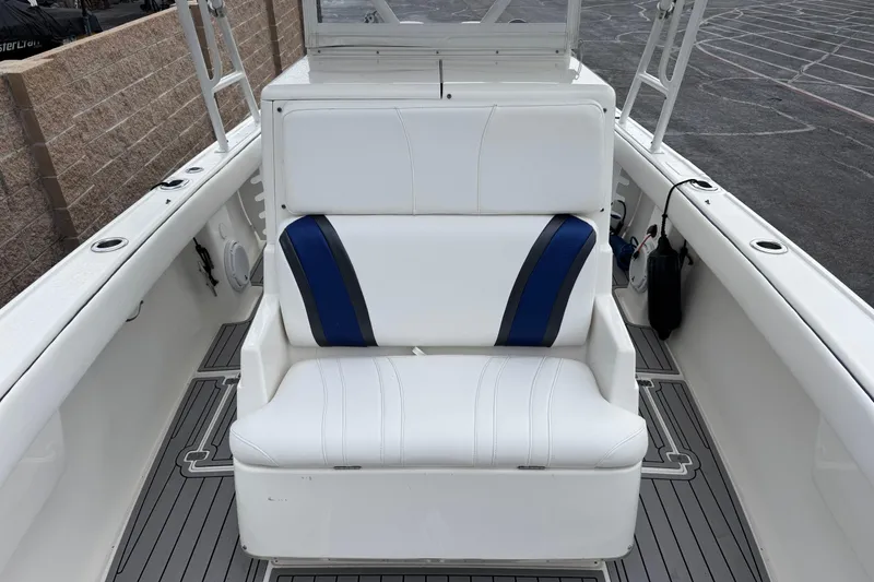 Slide: The Image of 2001 Intrepid 327 Center Console boat with white and blue seating, docked. - 10