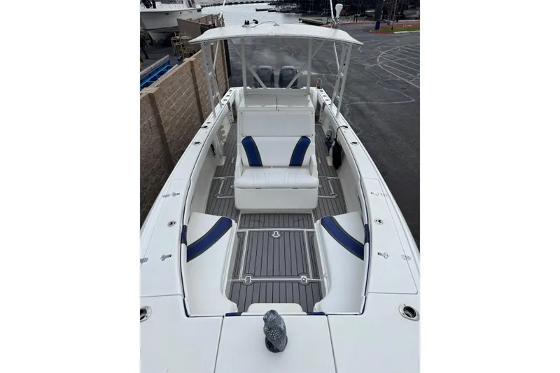 Slide: The Image of 2001 Intrepid 327 Center Console boat with white and blue seating, docked at marina. - 9