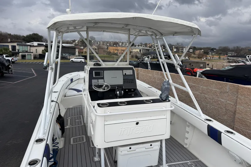 Slide: The Image of 2001 Intrepid 327 Center Console boat with helm, parked under cloudy skies. - 5