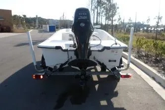 Slide: The Image of 2019 Mako Pro Skiff 17 CC boat on trailer, rear view, parked on road. - 2