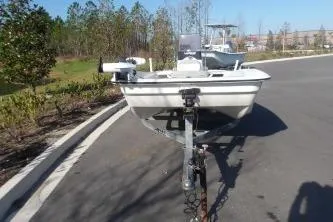 Slide: The Image of 2019 Mako Pro Skiff 17 CC boat on trailer, parked on a paved road. - 4