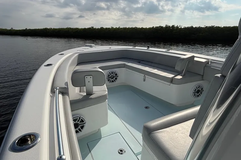 Slide: The Image of 2023 Contender 28 Sport boat interior with seating and speakers on calm water. - 12