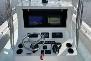 Slide: The Image of 2023 Contender 28 Sport boat dashboard with dual screens and steering wheel. - 4