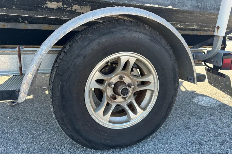 Slide: The Image of Trailer wheel of 2004 Grady-White Sportsman 180 boat on asphalt surface. - 13