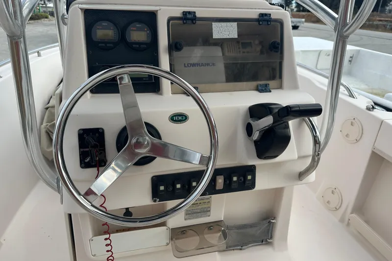 Slide: The Image of 2004 Grady-White Sportsman 180 boat dashboard with steering wheel and controls. - 22