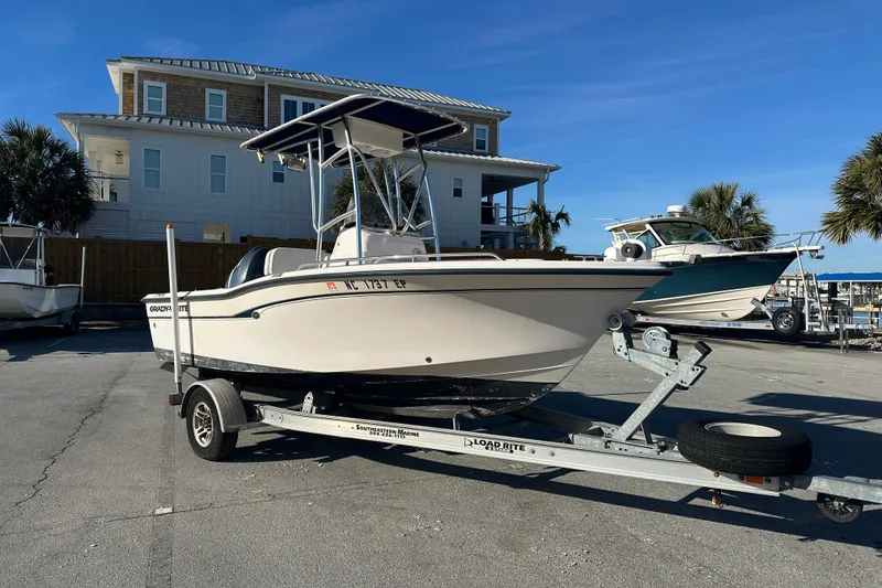 Slide: The Image of 2004 Grady-White Sportsman 180 boat on trailer, parked near coastal house. - 9