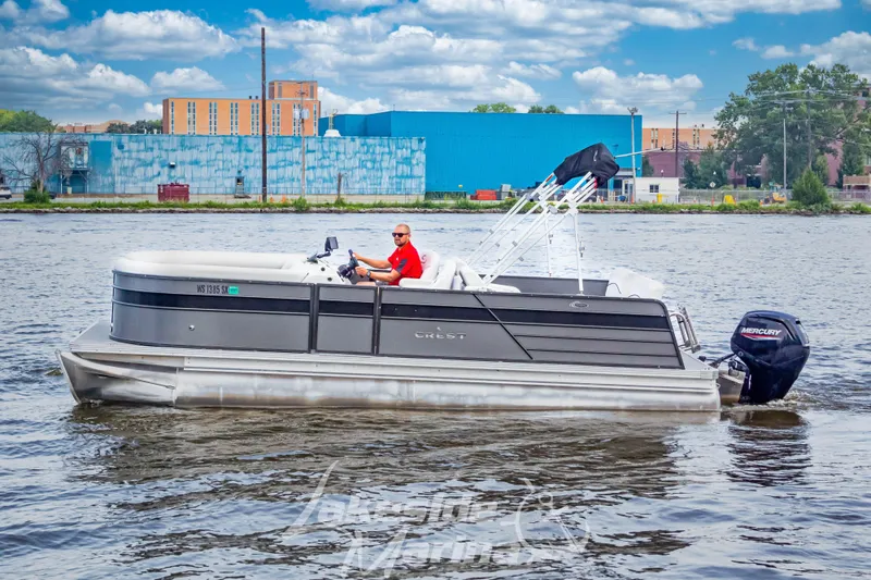 Slide: The Image of 2021 Crest Classic LX 220 SLRC pontoon boat on a river, with a Mercury outboard motor. - 11