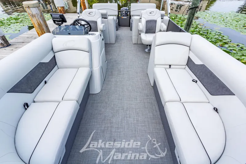 Slide: The Image of 2021 Crest Classic LX 220 SLRC pontoon boat interior with plush seating and steering console. - 13
