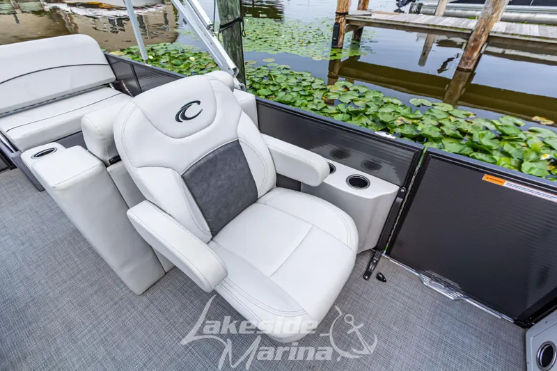 Slide: The Image of Luxury seating on 2021 Crest Classic LX 220 SLRC pontoon boat by a lakeside dock. - 18