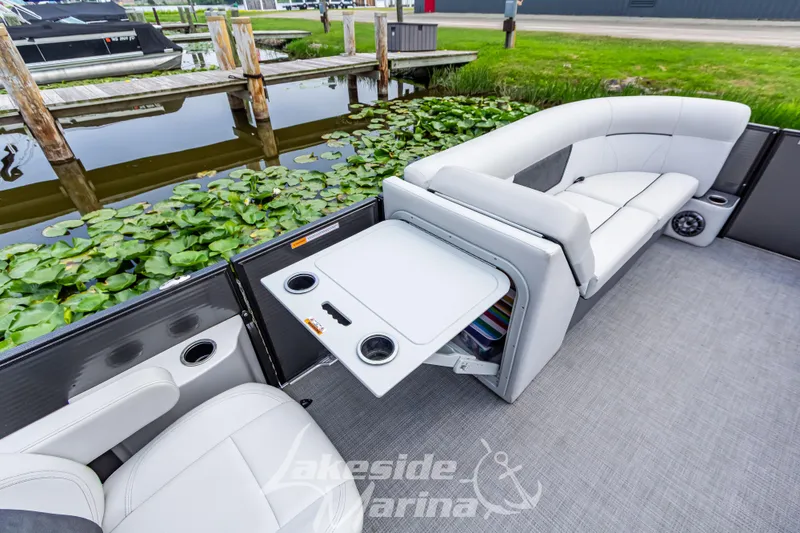 Slide: The Image of 2021 Crest Classic LX 220 SLRC boat interior with seating and table by a dock. - 20