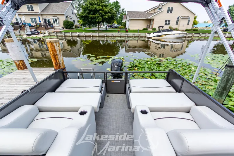 Slide: The Image of 2021 Crest Classic LX 220 SLRC pontoon boat docked by a serene lakeside. - 27