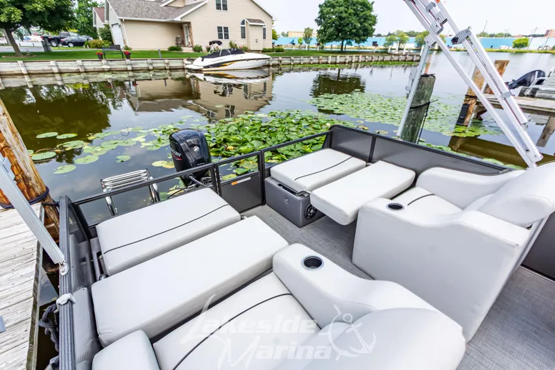 Slide: The Image of 2021 Crest Classic LX 220 SLRC pontoon boat with luxurious seating by a serene dock. - 28