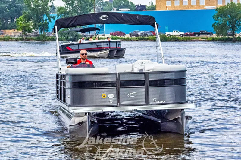 Slide: The Image of 2021 Crest Classic LX 220 SLRC pontoon boat cruising on a lake. - 3