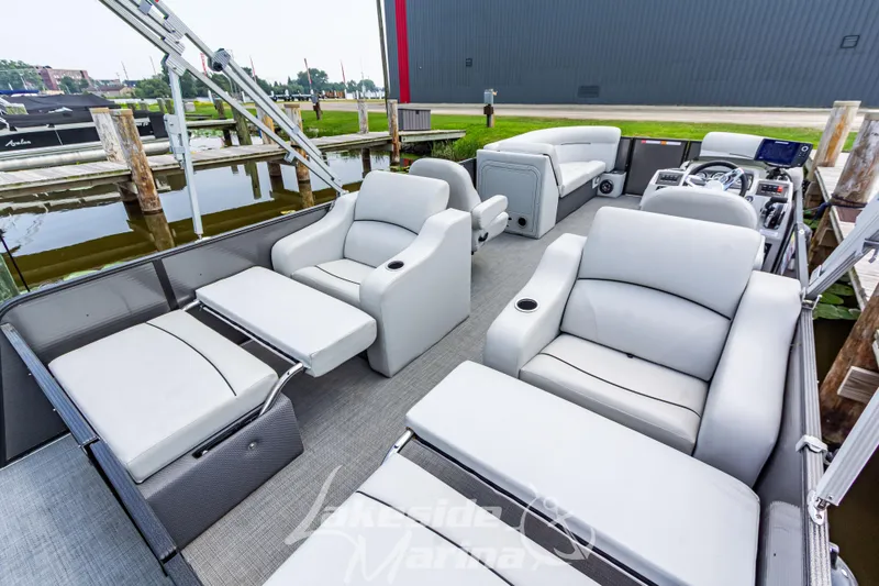 Slide: The Image of 2021 Crest Classic LX 220 SLRC pontoon boat with luxurious seating at a marina. - 31