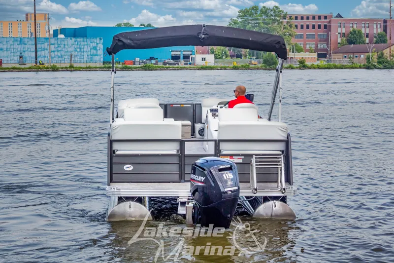 Slide: The Image of 2021 Crest Classic LX 220 SLRC pontoon boat on a lake, rear view. - 8