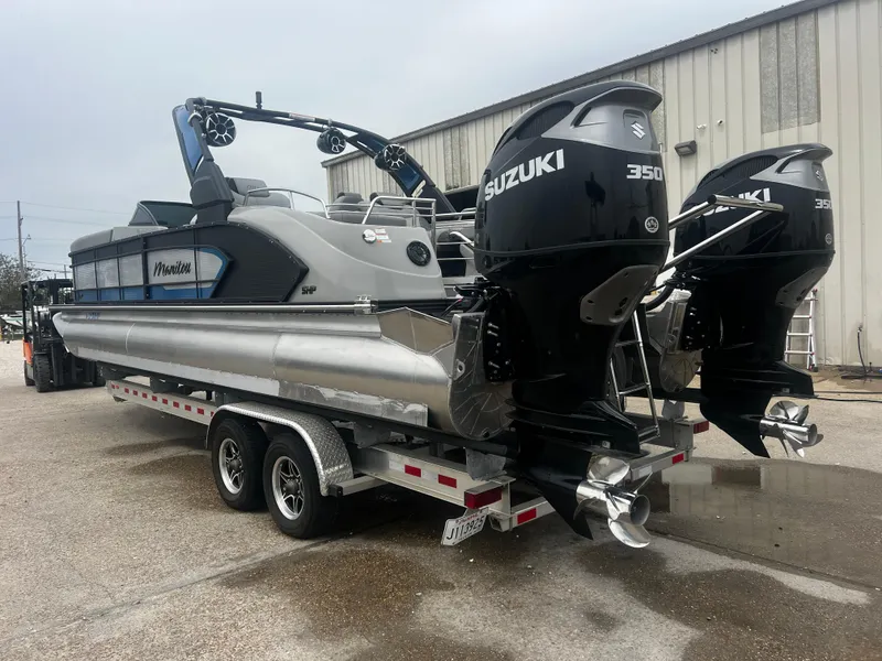Slide: The Image of 2022 Manitou 27 pontoon boat with dual Suzuki 350 engines on a trailer. - 13