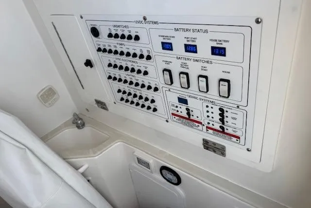 Slide: The Image of Electrical control panel on 2022 Edgewater 280CC boat, showing battery status and switches. - 12