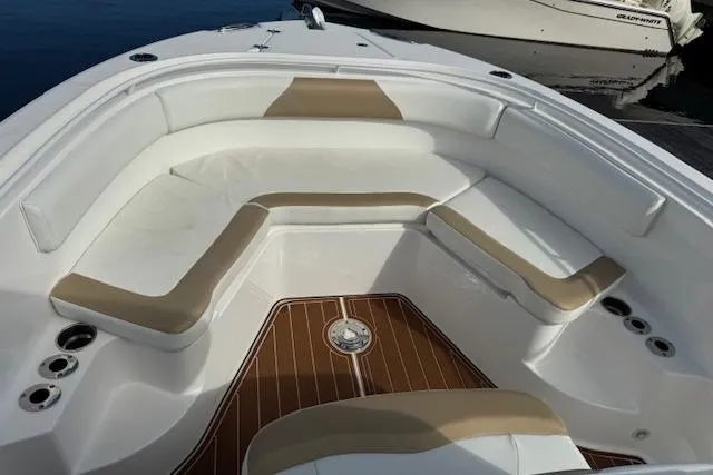 Slide: The Image of 2022 Edgewater 280CC boat interior with cushioned seating and wood-style flooring. - 13