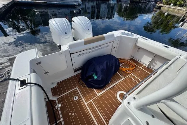 Slide: The Image of 2022 Edgewater 280CC boat interior with twin engines, docked by calm water. - 18