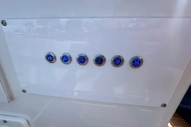 Slide: The Image of Control panel with six illuminated buttons on a 2022 Edgewater 280CC boat. - 21