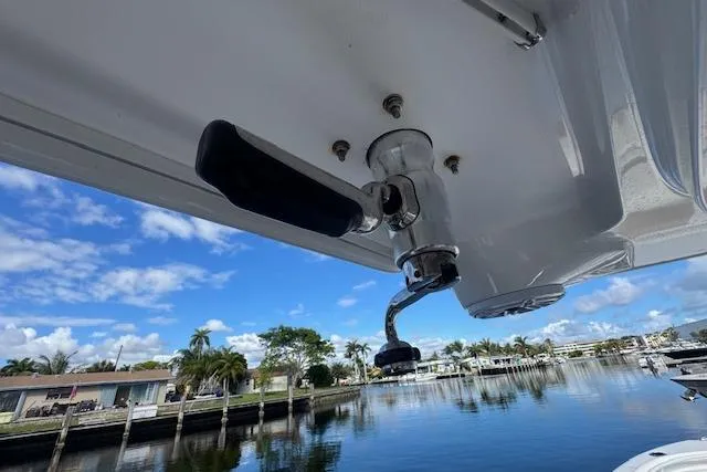 Slide: The Image of 2022 Edgewater 280CC boat detail with fishing rod holder, scenic waterfront view. - 23