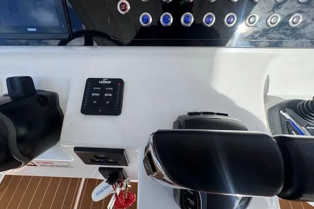 Slide: The Image of Control panel of 2022 Edgewater 280CC boat with switches and throttle levers. - 31