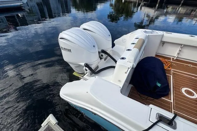 Slide: The Image of Edgewater 280CC 2022 boat with dual Yamaha outboard motors docked on calm water. - 4