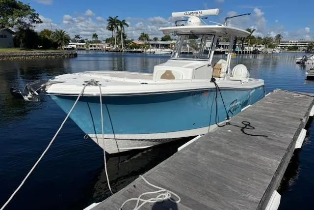 Slide: The Image of 2022 Edgewater 280CC boat docked on a sunny day with clear skies. - 8
