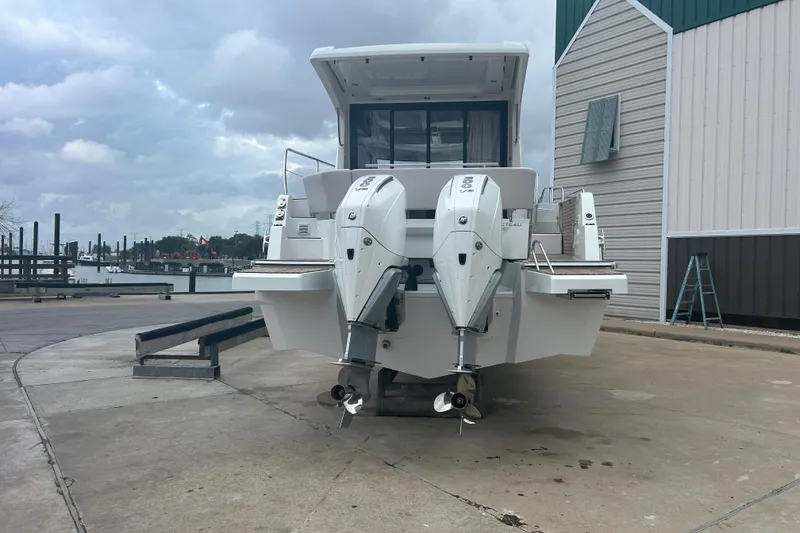 Slide: The Image of 2026 Beneteau Antares 11 Coupe cruising on a river, rear view with dual engines. - 2