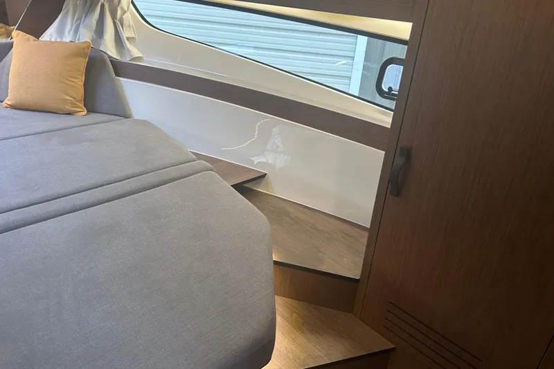 Slide: The Image of 2025 Beneteau Antares 11 Coupe interior wooden cabinet with open shelves. - 37