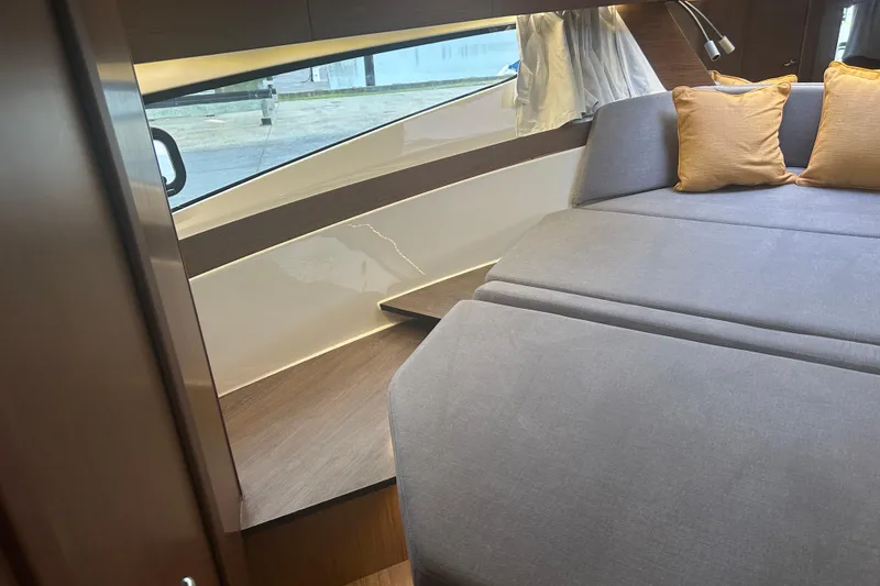 Slide: The Image of 2025 Beneteau Antares 11 Coupe interior with gray seating and yellow cushions. - 38
