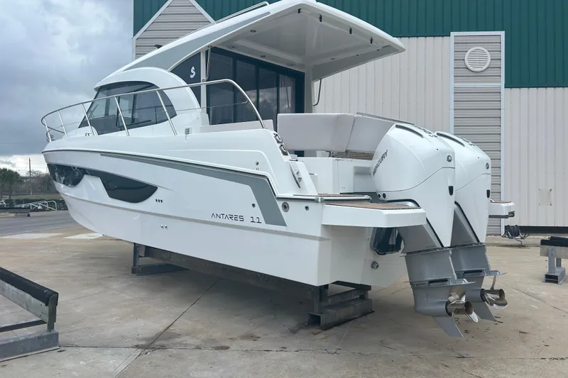 Slide: The Image of 2026 Beneteau Antares 11 Coupe cruising on a calm river near a marina. - 4
