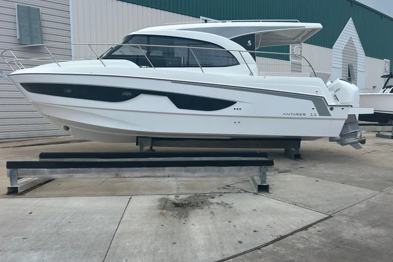 Slide: The Image of 2025 Beneteau Antares 11 Coupe with dual outboard engines on a dockside. - 7