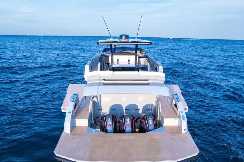 Slide: The Image of 2024 Rio Yachts Daytona 50 cruising on open water with city skyline in background. - 10