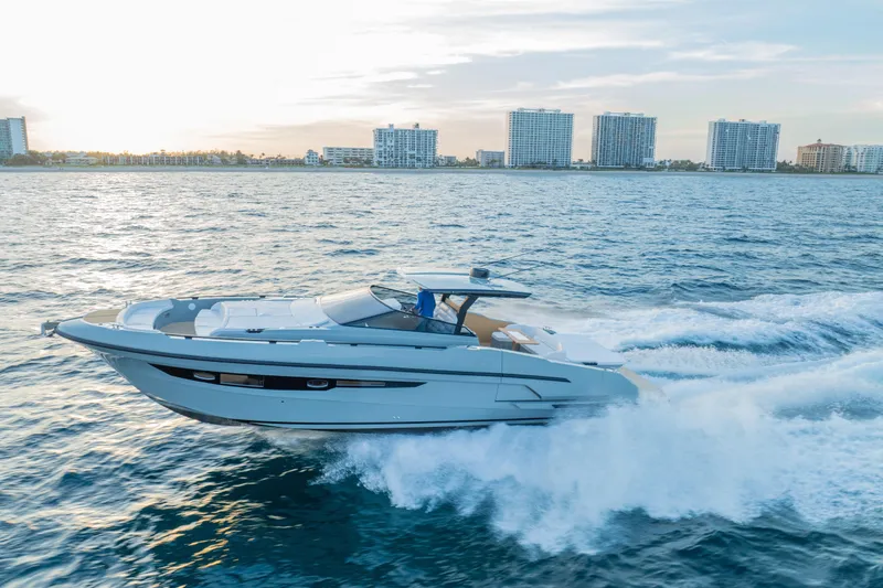 Slide: The Image of 2024 Rio Yachts Daytona 50 cruising on ocean near city skyline at sunset. - 2