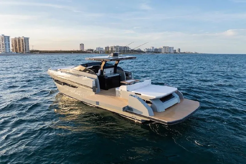 Slide: The Image of 2024 Rio Yachts Daytona 50 cruising on open water near coastal cityscape. - 9