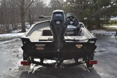 Slide: The Image of 2013 Tracker Super Guide V-16 SC boat with outboard motor, parked outdoors. - 6