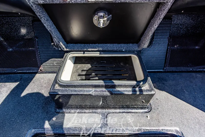 Slide: The Image of 2020 Triton 216 Fishunter boat storage compartment with open lid, showcasing interior details. - 23