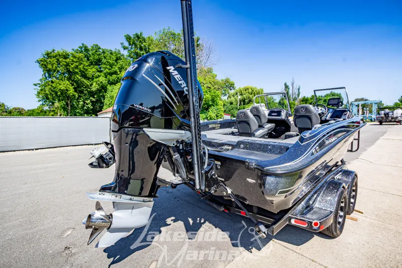 Slide: The Image of 2020 Triton 216 Fishunter boat with Mercury Verado engine, parked outdoors on a sunny day. - 6