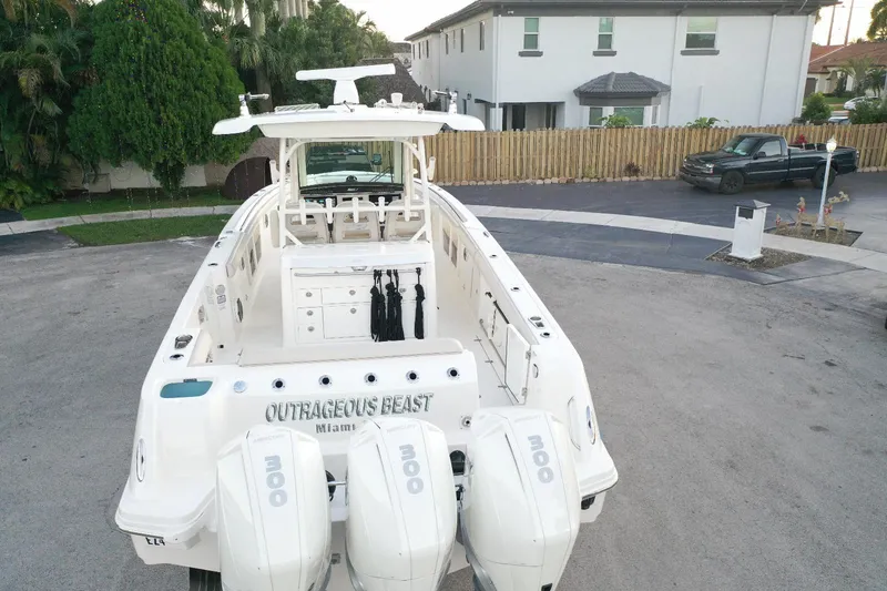 Slide: The Image of 2021 Boston Whaler 350 Outrage boat with triple outboard engines in a residential area. - 12